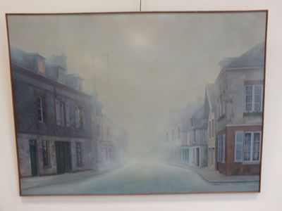 une peinture accrochée au mur d'un immeuble, avec une rue en arrière-plan