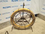 a wheel that is sitting on a stand in front of a wall