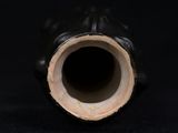 a close up of a black vase on a black surface