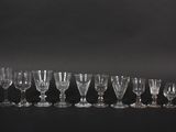six wine glasses are lined up in a row on a black surface
