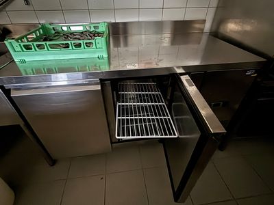un plan de travail en acier inoxydable avec un panier rempli d'aliments à l'intérieur