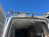 une camionnette blanche avec une échelle à l'arrière