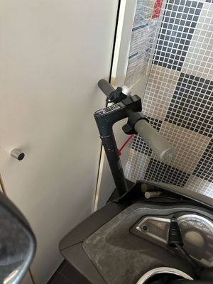 un scooter garé à côté d'une toilette dans des sanitaires