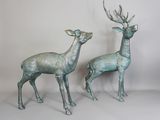une paire de statues de cerfs en bronze sur fond blanc