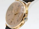 an image of a gold watch with a black strap