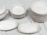 a lot of white plates and cups on a table