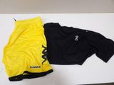 two yellow and black shorts sitting on top of a white table