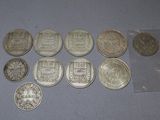 some silver coins sitting on top of a table next to a plastic bag