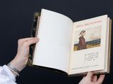 someone holding an open book with a picture of a woman on it