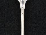 silver spoon on a black surface with a black background