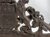 an antique wooden coat of arms with a lion and a shield