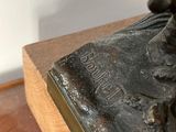 a statue of a man riding a horse on a wooden base