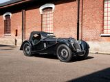 a black vintage car parked in front of a brick building