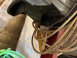 a black motor on a red stand next to a green hose