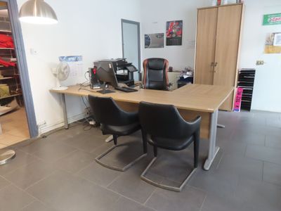 a desk with two chairs and a computer on top of it