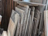 Plusieurs morceaux de bois sont empilés en tas près d'une fenêtre