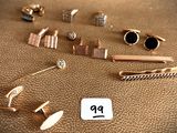 many different types of jewelry on a brown leather surface