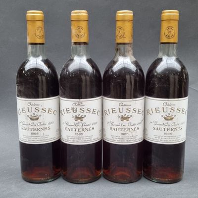 four bottles of wine are lined up on a table