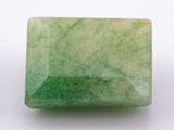 a close up of a green jade stone on a white surface