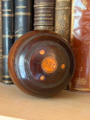 a clock that is on a shelf in front of a bunch of books