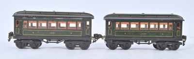 two toy trains sitting side by side on a white surface
