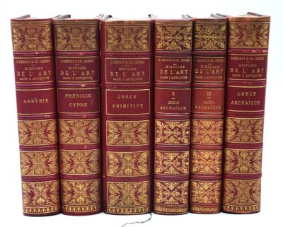 six livres rouges sont alignés sur une surface blanche