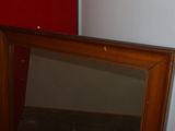 a mirror sitting on the floor next to a red wall