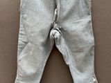 grey pants hanging on a clothes line on a brown surface