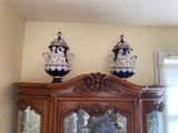 two blue and white vases on top of a wooden cabinet
