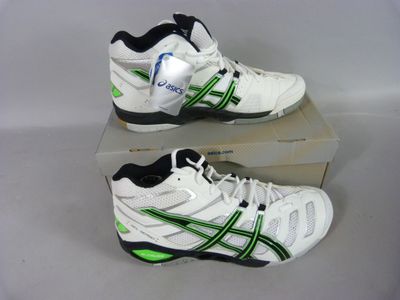 two pairs of white and green tennis shoes sitting on top of a box