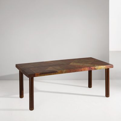 La table est en bois et présente un motif géométrique.