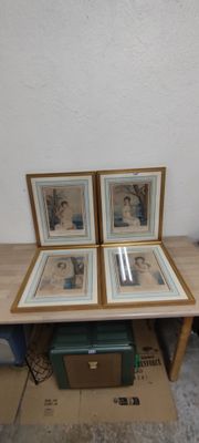 three framed pictures on a table in a room