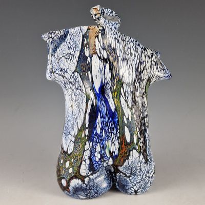 un vase bleu et blanc surmonté d'un oiseau