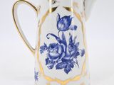 a blue and white pitcher with gold trimmings