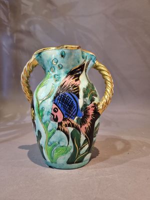 a blue and green vase with a fish design on it