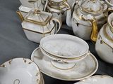 a lot of white and gold china on a table