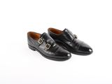 une paire de chaussures en cuir noir avec une boucle dorée