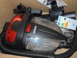 un aspirateur rouge et noir rangé dans une boîte