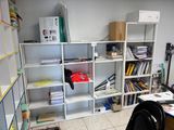 a room with a desk, shelves, and a chair in it