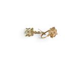 un gros plan sur une paire de boucles d'oreilles en or sur fond blanc