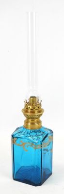 une petite bouteille en verre bleue avec un bouchon doré