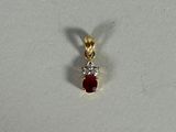 a close up of a red and white diamond pendant on a white surface