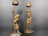 paire de figurines anciennes en bronze représentant un homme et une femme tenant des cruches d'eau