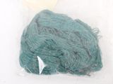 a green yarn in a plastic bag on a white surface
