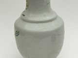 a green vase with a bird design on it