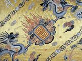 an image of a yellow oriental rug with a dragon and flowers on it