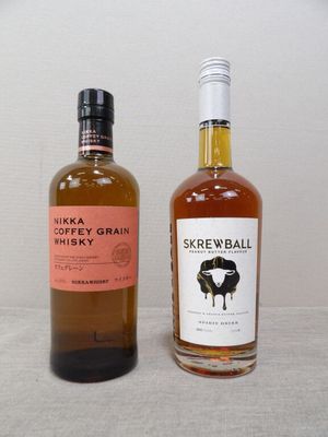 deux bouteilles de whisky posées l'une à côté de l'autre sur une table