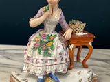 a figurine of a woman sitting on a table
