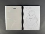 a close up of a notebook with a drawing of a bearded man