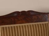 a bed with a wooden headboard and a striped pillow